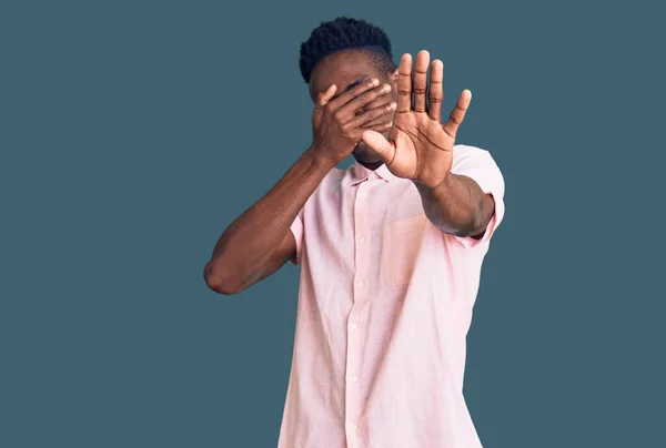 Young African American Man Wearing Casual Clothes Covering Eyes Hands — Stock Photo, Image