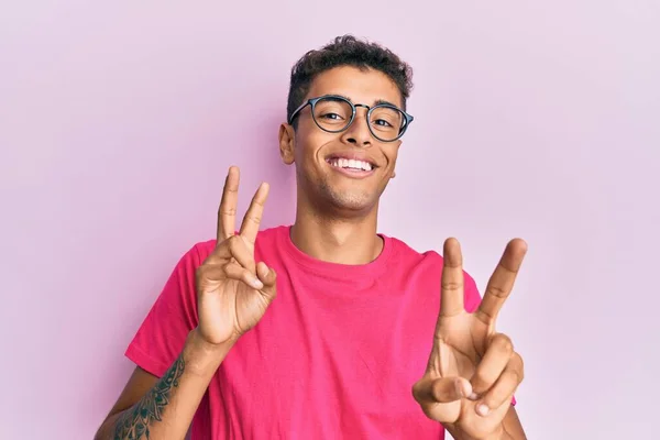 Молодий Афроамериканець Одягнений Окуляри Над Рожевим Фоном Посміхається Дивлячись Камеру — стокове фото