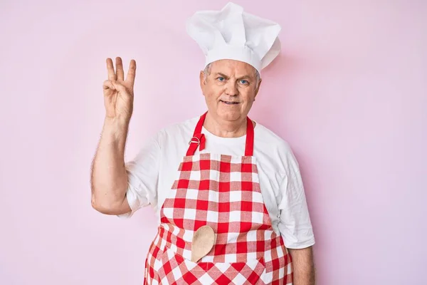 Senior Grauhaarige Mann Trägt Professionelle Bäckerschürze Zeigt Und Zeigt Mit — Stockfoto