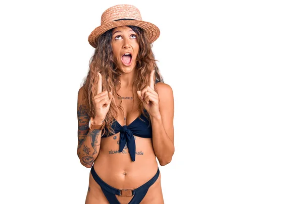 Jonge Spaanse Vrouw Met Tatoeage Bikini Zomerhoed Verbaasd Verrast Omhoog — Stockfoto