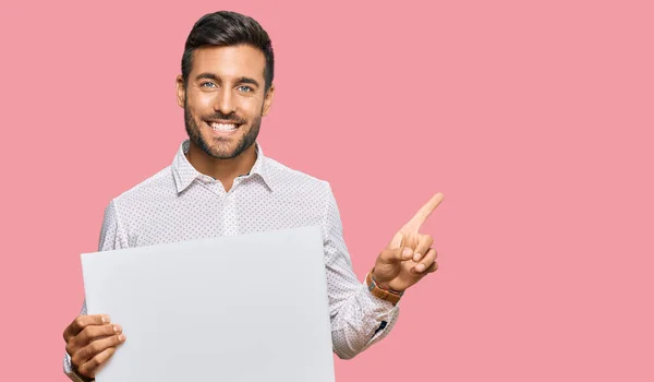 Handsome Hispanic Man Holding Blank Empty Banner Smiling Happy Pointing — Stock Photo, Image