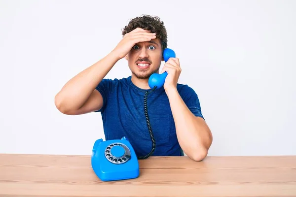Молодой Кавказский Мужчина Вьющимися Волосами Используя Винтажный Телефон Сидящий Столе — стоковое фото