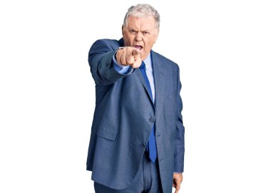 İş ceketi giyen yaşlı, gri saçlı adam kameraya kızgın ve sinirli olduğunu gösteriyor. 