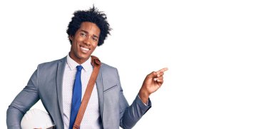 Yakışıklı, Afro saçlı, mimar şapkalı, eli ve parmağı yanda mutlu bir şekilde gülümseyen Afrikalı bir Amerikalı. 