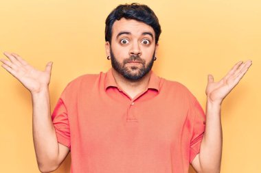 Gündelik kıyafetler giyen genç İspanyol adam habersiz ve kolları açık, hiçbir fikri ve şüpheli bir yüzü var.. 