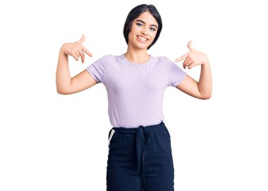 Esmer, sıradan kıyafetler giyen, kendine güvenen, gülümseyen, kendini gururlu ve mutlu gösteren bir genç kız.. 