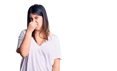 Genç, güzel, esmer bir kadın günlük tişörtler giyiyor. Kokuşmuş ve iğrenç bir koku alıyor. Dayanılmaz bir koku. Kötü kokuyor. 