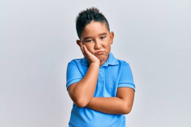 Günlük kıyafetler giyen İspanyol çocuk kollarını kavuşturup depresyondan sıkılmış ve yorgun görünüyor.. 