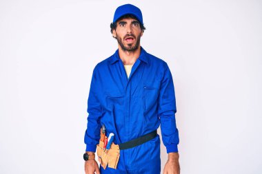 Kıvırcık saçlı, ayı gibi giyinen, şaşkın yüzlü, kuşkucu ve iğneleyici bakışlı, ağzı açık ve şaşırmış genç bir adam. 