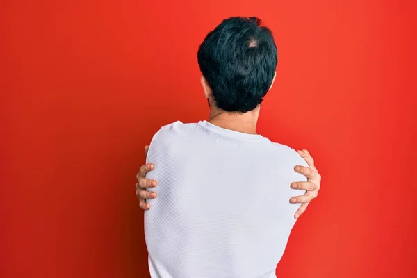 Νεαρός Ισπανός Που Φοράει Λευκό Μπλουζάκι Αγκαλιάζοντας Τον Εαυτό Του — Φωτογραφία Αρχείου