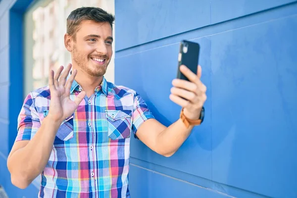 Joven Hombre Caucásico Sonriendo Feliz Haciendo Videollamada Usando Smartphone Ciudad —  Fotos de Stock