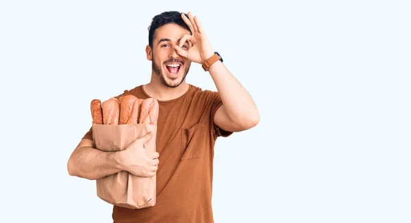 Joven Hombre Hispano Sosteniendo Bolsa Papel Con Pan Sonriendo Feliz —  Fotos de Stock