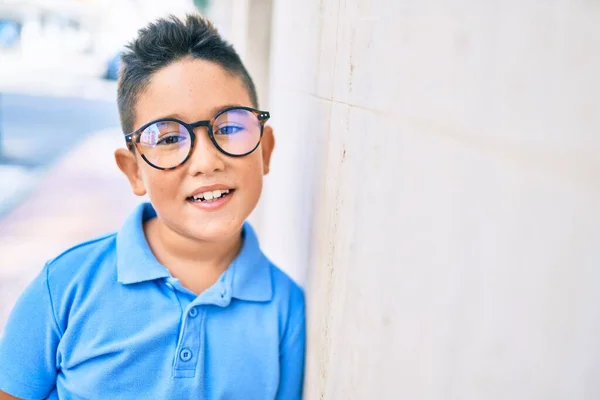 在城市的大街上 一个戴眼镜的可爱的男孩靠在墙上 — 图库照片