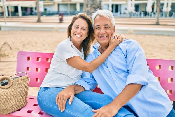 Casal Hispânico Meia Idade Sorrindo Feliz Abraçando Sentado Banco Praia — Fotografia de Stock