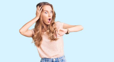 Sarışın, güzel, beyaz bir kadın. Günlük kıyafetler giyiyor. Saatine bakıyor. Endişeli, geç kalmaktan korkuyor. 