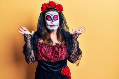 Sarı üzerine ölü kostümü giymiş genç bir kadın çılgınlığı kutluyor ve başarıya hayret ediyor. Kolları açık, gözleri açık heyecanla haykırıyor. Kazanan konsept 