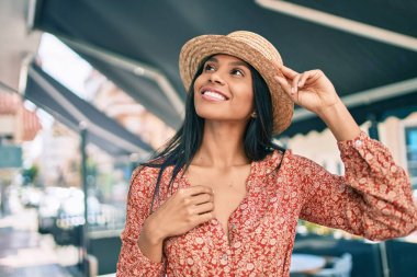 Genç Afro-Amerikan turist kadın tatilde gülümseyerek şehirde mutlu bir şekilde yürüyor..