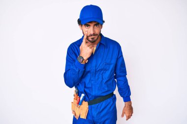 Kıvırcık saçlı ve ayı gibi giyinen yakışıklı genç adam. Gözünü dikip jestini izliyor. Şüpheli bir ifade. 