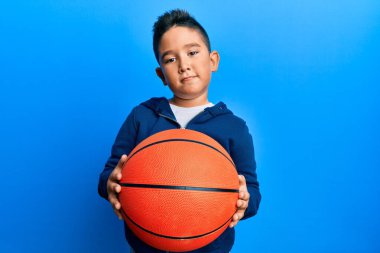 Basketbol topu tutan küçük İspanyol çocuk yüzünde ciddi bir ifadeyle rahatlamış. Basit ve doğal bir şekilde kameraya bakıyorsun.. 