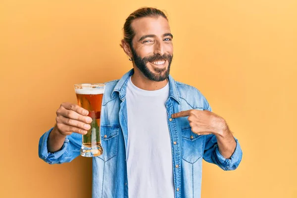 Atrakcyjny Mężczyzna Długimi Włosami Brodą Pijący Kufel Piwa Wskazujący Palcem — Zdjęcie stockowe