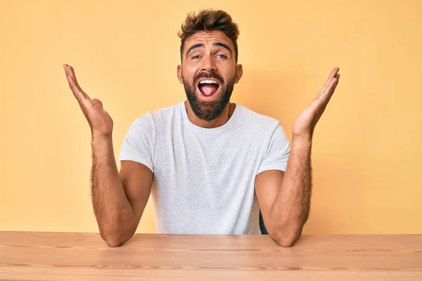 Giovane Uomo Ispanico Indossa Abiti Casual Seduto Sul Tavolo Celebrando — Foto Stock