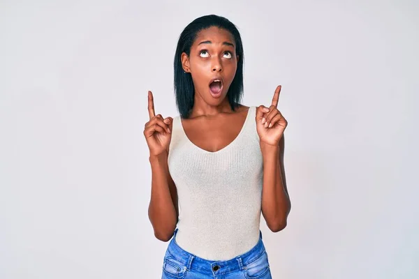 Mujer Afroamericana Joven Vestida Con Ropa Casual Asombrada Sorprendida Mirando —  Fotos de Stock