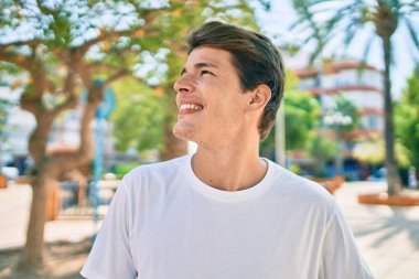 Genç beyaz adam gülümsüyor.