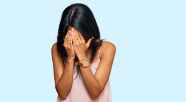 Genç Afro-Amerikalı kadın, günlük kıyafetler ve gözlük takıyor ve ağlarken suratını ellerle kapatıyor. depresyon kavramı. 