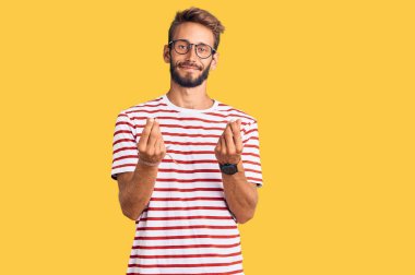 Sakallı, sıradan kıyafetler ve gözlük takan yakışıklı sarışın adam. Parayla hareket eden, maaşını isteyen, milyoner iş adamı. 