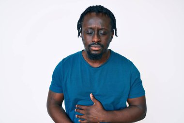 Saçları örgülü, elleri karnında, günlük kıyafetler giyen genç Afro-Amerikalı bir adam. Çünkü hazımsızlık, acı verici bir hastalık ve kendini iyi hissetmiyor. Ağrı kavramı. 