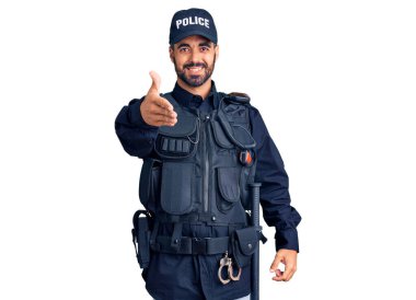 Polis üniforması giyen genç İspanyol adam selamlama ve hoş geldin demek için dostça el sıkışma teklif ediyor. başarılı iş. 