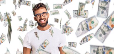 Gündelik kıyafetler giyen ve gözlüklü genç İspanyol adam kameraya seksi bir ifadeyle bakıyor, neşeli ve mutlu bir yüzle..