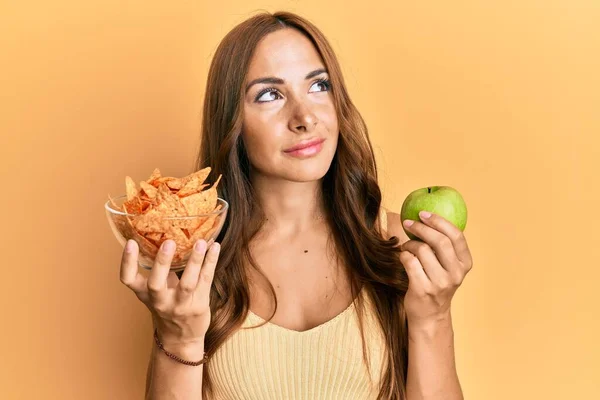 Young Brunette Woman Holding Nachos Healthy Green Apple Smiling Looking — Stock Photo, Image
