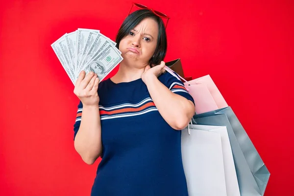 Mujer Morena Con Síndrome Sosteniendo Bolsas Compras Dólares Deprimidos Preocuparse —  Fotos de Stock