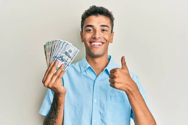 Joven Hombre Afroamericano Guapo Sosteniendo Dólares Sonriendo Feliz Positivo Pulgar —  Fotos de Stock