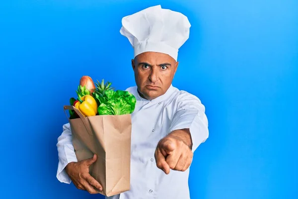 Maduro Hombre Oriente Medio Chef Profesional Sosteniendo Bolsa Comestibles Señalando —  Fotos de Stock