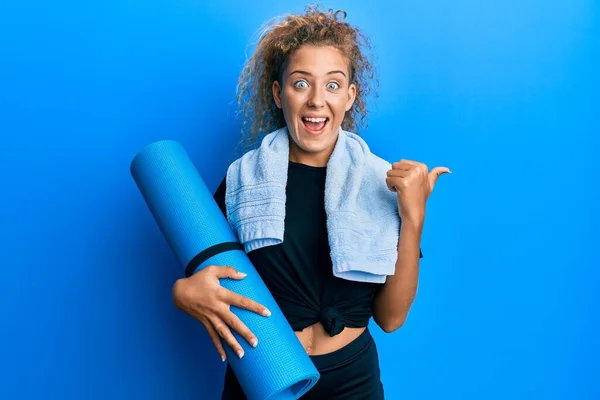 Hermosa Chica Adolescente Caucásica Sosteniendo Estera Yoga Apuntando Pulgar Hacia — Foto de Stock