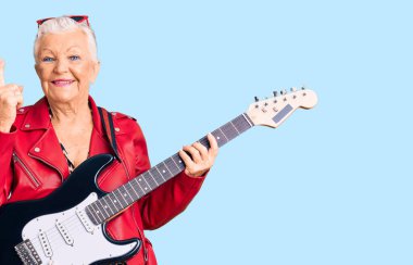Son sınıf güzeli, mavi gözlü, gri saçlı modern görünümlü başarılı bir fikirle elektro gitar çalan bir kadın. Heyecanlı ve mutlu. Bir numara.. 