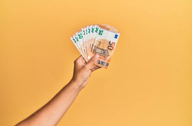 50 avroluk banknotları izole edilmiş sarı arka planda tutan İspanyol bir adam..