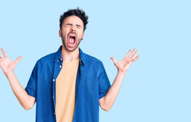 Gündelik kıyafetler giyen genç İspanyol adam başarı için deli ve çılgınlığı kutluyor kollarını kaldırmış ve gözlerini kapatmış heyecanla bağırıyor. Kazanan konsept 