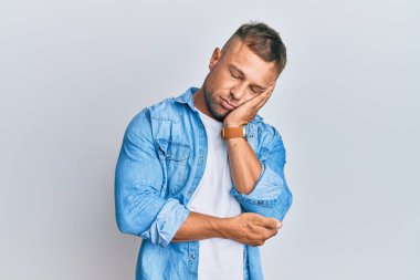 Yakışıklı, sıradan bir kot ceket giyen ve kollarını kavuşturarak depresyondan sıkılmış görünen kaslı bir adam.. 