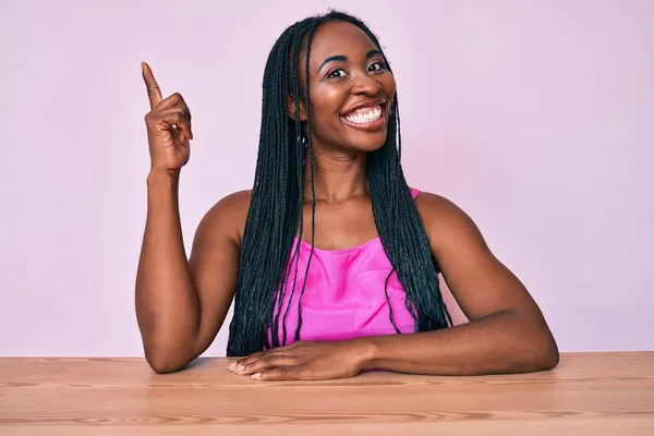 Mujer Afroamericana Con Trenzas Con Ropa Casual Sentada Mesa Señalando —  Fotos de Stock