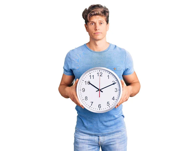 Jovem Homem Bonito Segurando Grande Relógio Pensando Atitude Expressão Sóbria — Fotografia de Stock