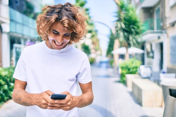 Şehrin Caddesinde Akıllı Telefon Kullanan Mutlu Gülümseyen Genç Spanyol Adam — Stok fotoğraf