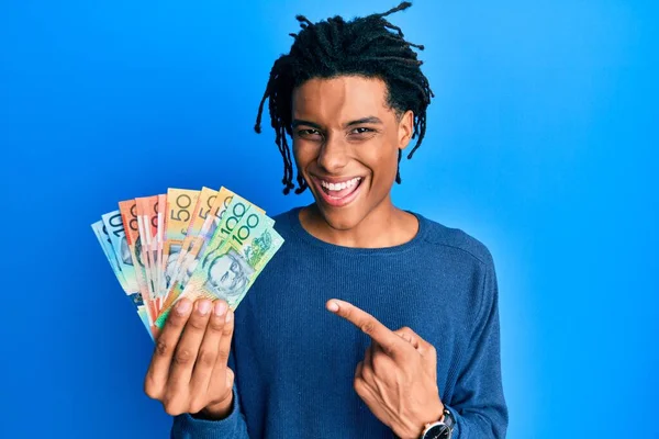 Νεαρός Αφροαμερικάνος Που Κρατάει Αυστραλιανά Δολάρια Χαμογελώντας Χαρούμενος Δείχνοντας Χέρι — Φωτογραφία Αρχείου