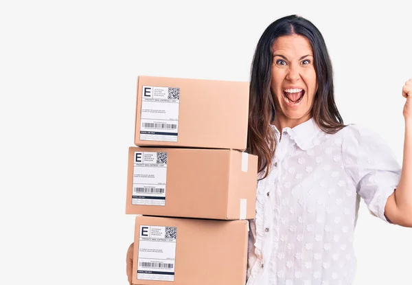 Jovem Bela Mulher Morena Segurando Pacote Papelão Entrega Gritando Orgulhoso — Fotografia de Stock