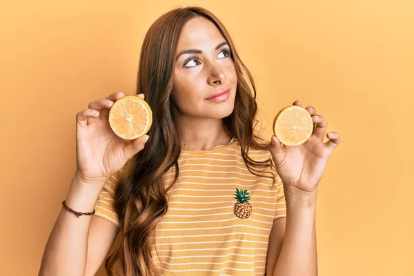 Giovane Donna Bruna Che Tiene Arancia Fresca Sorridente Guardando Lato — Foto Stock