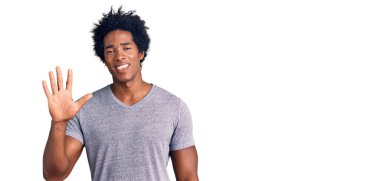 Yakışıklı Afro saçlı, sıradan giyinmiş, 5 numarayı işaret eden, kendinden emin ve mutlu gülümseyen Afro-Amerikan adam.. 
