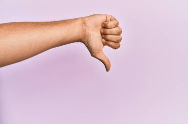 Pembe izole edilmiş arka plan üzerinde beyaz bir gencin kolu ve eli reddedilme jesti, onaylanmama ve olumsuz işaret yapıyor. 