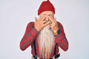 Gri saçlı, uzun sakallı, hippi görünümlü yaşlı bir adam. Yorgunluk ve baş ağrısı için gözlerini ovuşturan, uykulu ve yorgun bir ifade. görme sorunu 